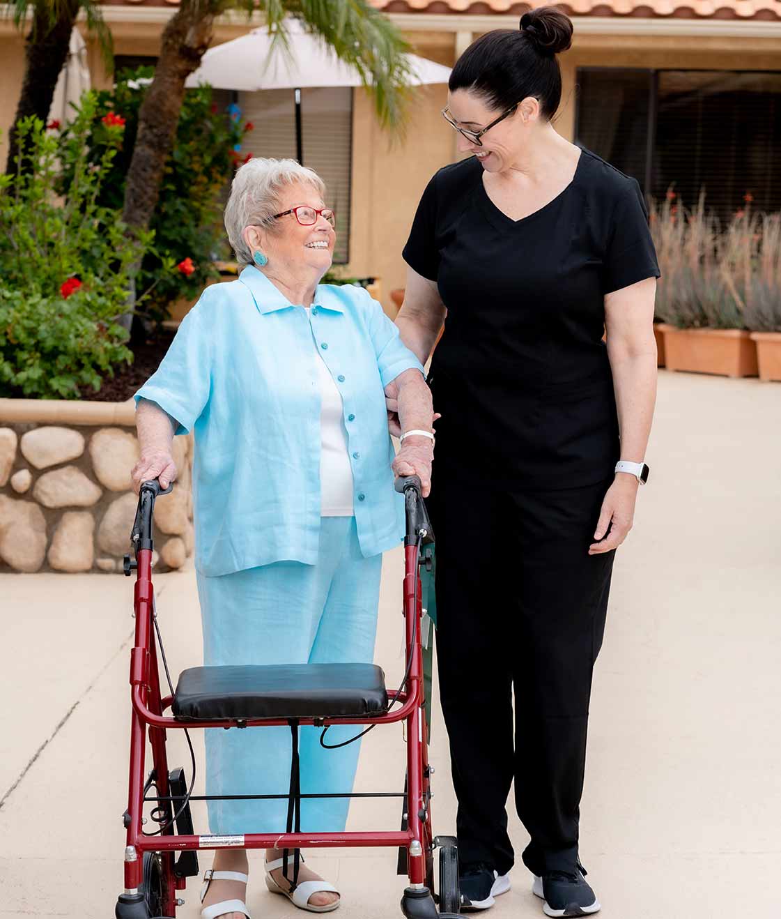 three senior women laughing while sharing a meal