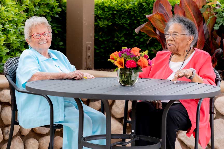 senior woman sitting outside on a patio drinking tea